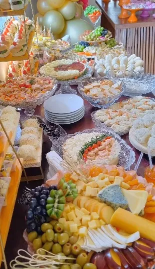 Mesa de festa completa com salgados e frutas